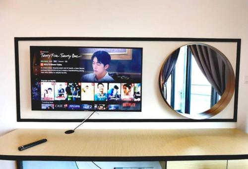 a television on a wall with a mirror at 1719 Almas Suites Muji Studio100mbpsNetflix By STAY in Nusajaya