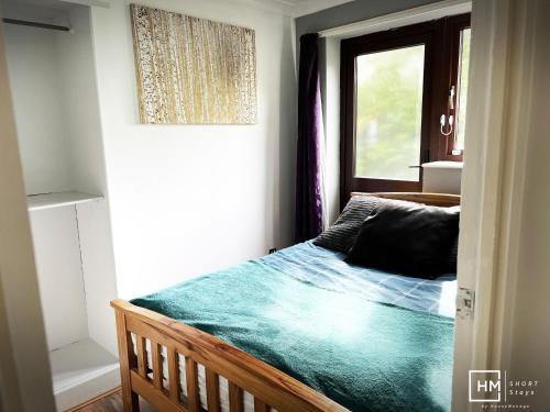 a small bedroom with a bed with a window at Enfield House - Beautiful 2 Bed - Good Transport Free Parking in Enfield Lock