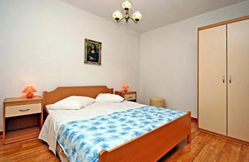 a bedroom with a large bed with a blue blanket at Apartments with a parking space Bol, Brac - 4659 in Bol