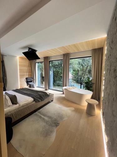 a bedroom with a large bed and a tub and windows at Garden Retreat Junior in Bran