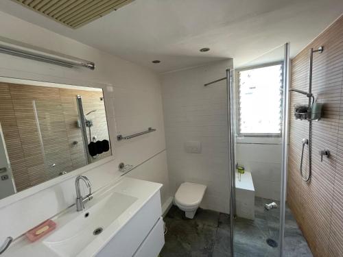 y baño con lavabo, aseo y ducha. en Beautiful 2-bedroom condo in the heart of Tel Aviv en Tel Aviv