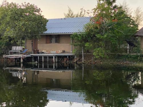 a house sitting on a river with a house at Numpu Baandin in Sam Roi Yot