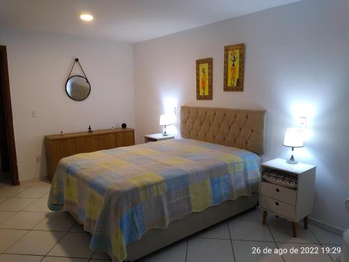 um quarto com uma cama e duas mesas de cabeceira e dois candeeiros em Cantinho Bonsai no Rio de Janeiro