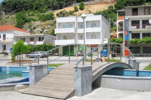 un puente de madera sobre una masa de agua con edificios en Studio Omis 4654b, en Omiš