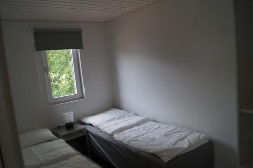 カロンボーにあるKalundborg Campingのベッド2台と窓が備わる小さな客室です。