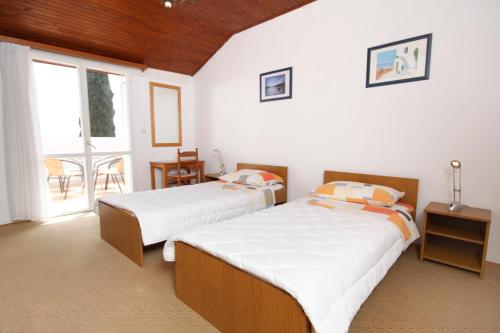 2 letti in una camera d'albergo con finestra di Apartments with a parking space Dubrovnik - 4673 a Dubrovnik