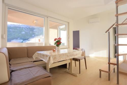ein Wohnzimmer mit einem Tisch und einem Sofa in der Unterkunft Apartments by the sea Duce, Omis - 4795 in Dugi Rat