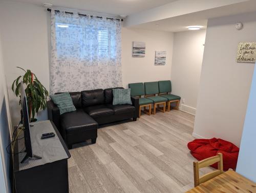 uma sala de estar com um sofá e duas cadeiras em Livingston Howse Haven - A simple & cozy private two-bedroom basement suite with free parking em Calgary