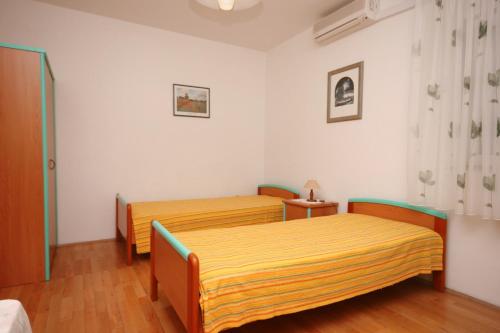 two beds in a room with white walls and wooden floors at Studio Nemira 4652c in Tice