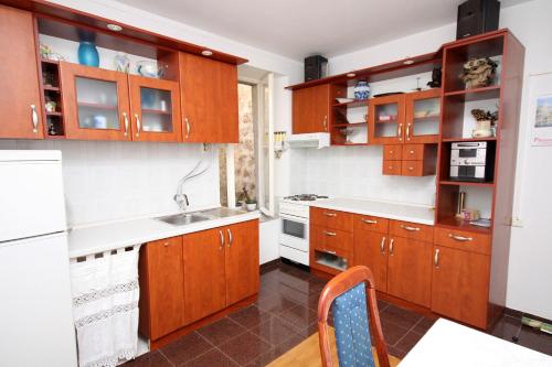 una cocina con armarios de madera y fregadero en Apartments by the sea Dubrovnik - 4698, en Dubrovnik