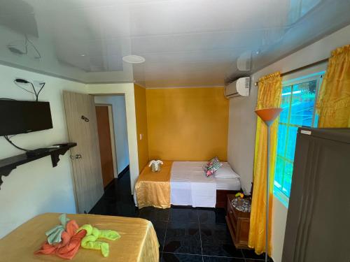 a small room with two beds and a tv at Posada Ashanty in Providencia