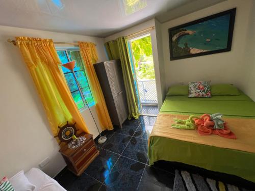 1 dormitorio con 2 camas y ventana en Posada Ashanty, en Providencia