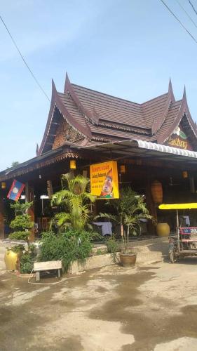 a building with a sign in front of it at Lao Long Riverside and Budget Garden Guesthouse in Ban Khon