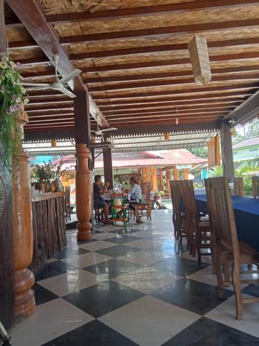 a restaurant with a checkered floor and tables and chairs at Lao Long Riverside and Budget Garden Guesthouse in Ban Khon