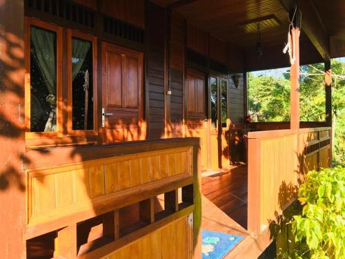 um alpendre frontal de uma casa com uma cerca de madeira em Panorama Cottage em Bunaken