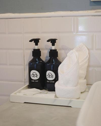 two bottles of soap and toilet paper on a shelf at Indie Beach Bungalows in Ko Chang