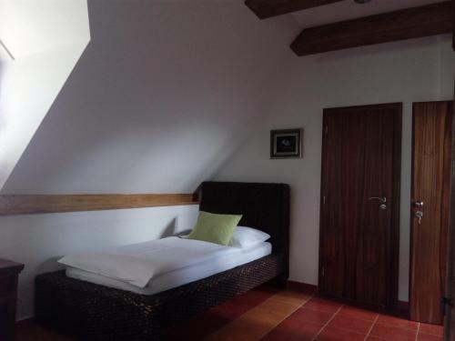 a bedroom with a bed with a green pillow on it at Penzion Rozmarýn in Vsetín