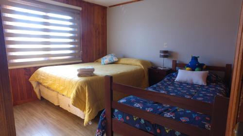 a small bedroom with two beds and a window at Santa Elena de Maipo Home in Temuco