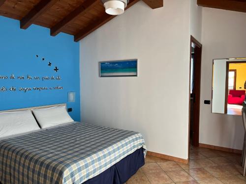 1 dormitorio con 1 cama con manta a cuadros en Color House Malpensa B&B, en Cassano Magnago