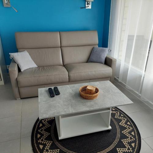 a living room with a couch and a coffee table at Studio proche plages / En couple ou avec enfants in Bénodet