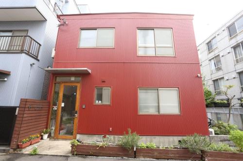 a red house with white windows and a red door at GrapeHouse Koenji in Tokyo