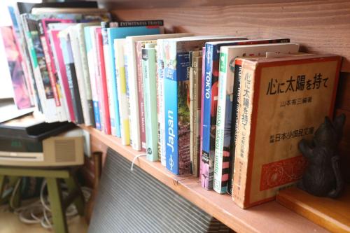 a row of books sitting on a shelf at GrapeHouse Koenji in Tokyo