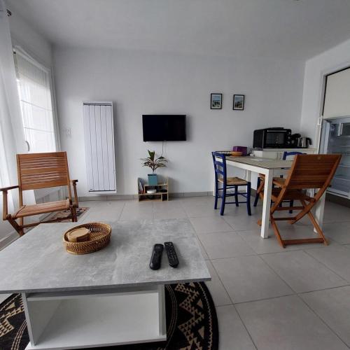 a living room with a table and chairs at Studio proche plages / En couple ou avec enfants in Bénodet