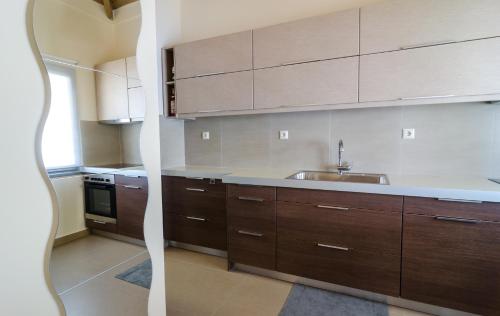 a kitchen with wooden cabinets and a sink at VergaView Luxury House in Kalamata
