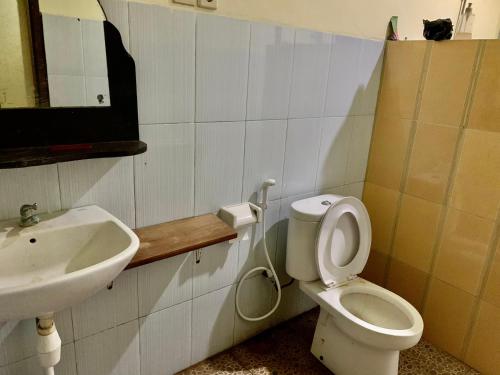 a bathroom with a toilet and a sink at Anugrah Bungallow in Gili Islands
