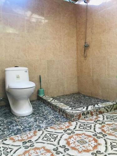 a bathroom with a toilet and a shower stall at Panorama Cottage in Bunaken