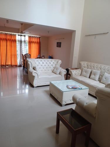 a living room with white couches and a coffee table at The Villa in Gurgaon