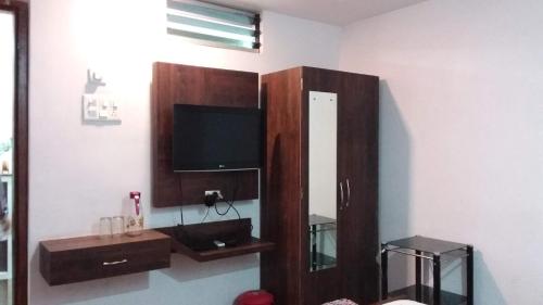 sala de estar con TV y armario de madera en HOTEL SWAGAT, en Bokāro