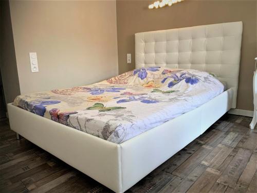 a bed in a bedroom with a white bed frame at Maison de FLO Centre Historique Argeles sur mer in Argelès-sur-Mer