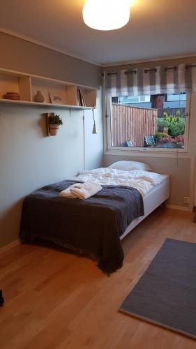 1 dormitorio con 1 cama grande y ventana en 3 bedrooms home with nice terrace, en Stavanger