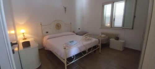 una piccola camera bianca con un letto e una finestra di La Maison à la Mer - Appartamentino a 200 mt dal mare a Giulianova