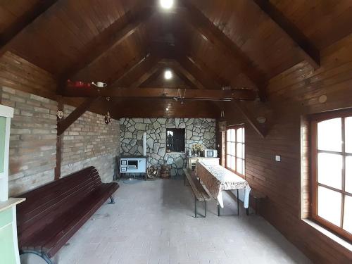 an empty room with benches and a stone wall at Szilvaliget Vendégház in Tolcsva