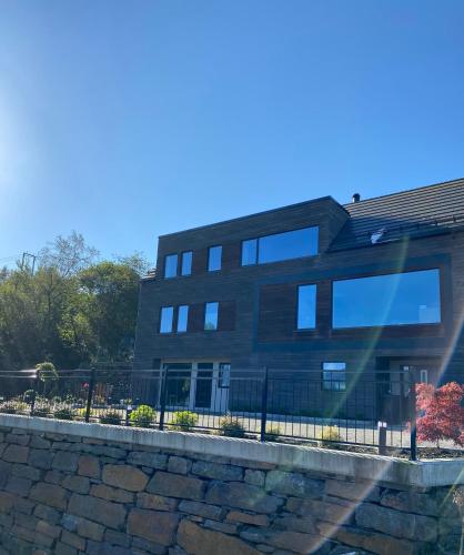 a black building with a fence in front of it at Havn i Etne with fjordview in Etnesjøen
