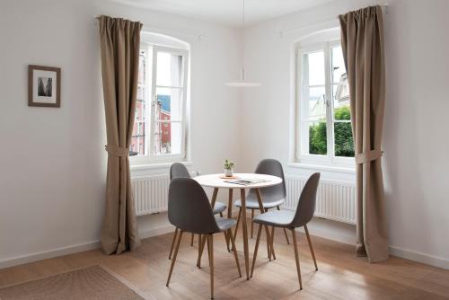 a dining room with a table and chairs and windows at Quartier 99 in Innsbruck