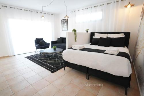 Uma cama ou camas num quarto em YalaRent Afarsemon Apartments with pool - For Families & Couples