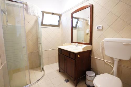 a bathroom with a toilet and a sink and a shower at YalaRent Afarsemon Apartments with pool - For Families & Couples in Eilat