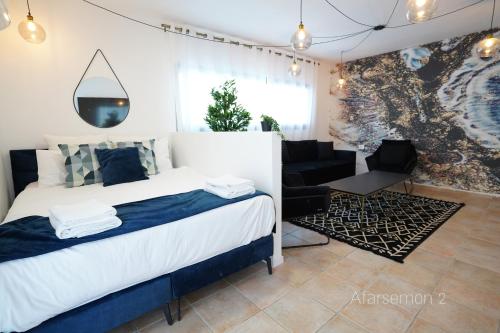 a bedroom with a bed and a chair and a couch at YalaRent Afarsemon Apartments with pool - For Families & Couples in Eilat