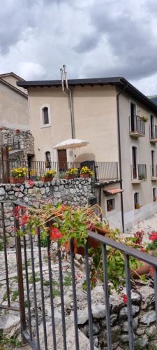 un edificio con sombrilla y algunas flores en Casa vacanze al Castello en Villetta Barrea