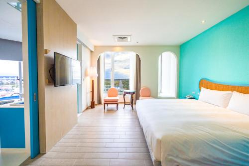 a hotel room with a large bed and a table at Kenting Long Beach Hotel in Checheng