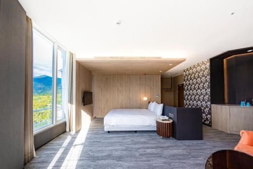 a hotel room with a bed and a large window at Kenting Long Beach Hotel in Checheng