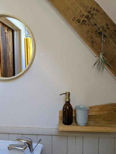 a bathroom counter with a mirror and a sink at La Kahana - cottage paisible, jardin fleuri & permaculture in Lescouët-Gouarec