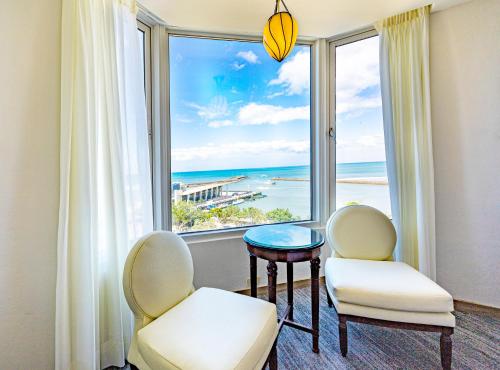 a room with two chairs and a table and a large window at Kenting Long Beach Hotel in Checheng