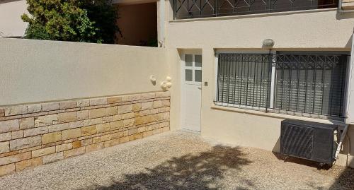 a front door of a house with a fence at HoneyBee 1 - Sunny Studio in the center of Rafina in Rafina