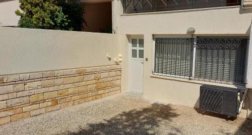 une porte d'entrée d'une maison avec une clôture dans l'établissement HoneyBee 1 - Sunny Studio in the center of Rafina, à Rafína