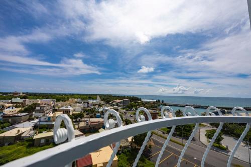 a balcony with a view of a city and the ocean at Kenting Long Beach Hotel in Checheng