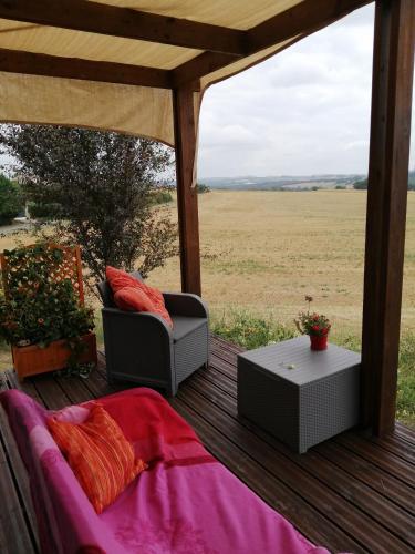a patio with a couch and a table on a deck at La petite maison dans la prairie 